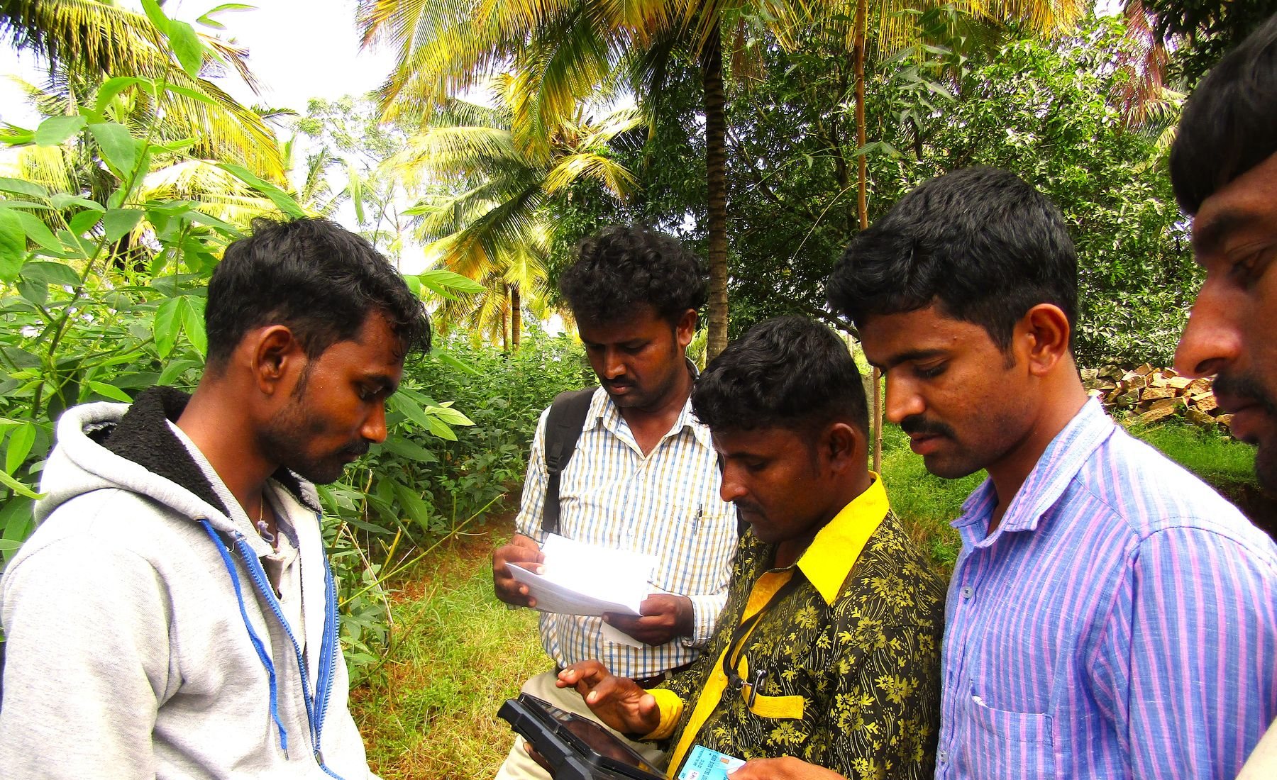 Field staff recording information with farmers on a tablet