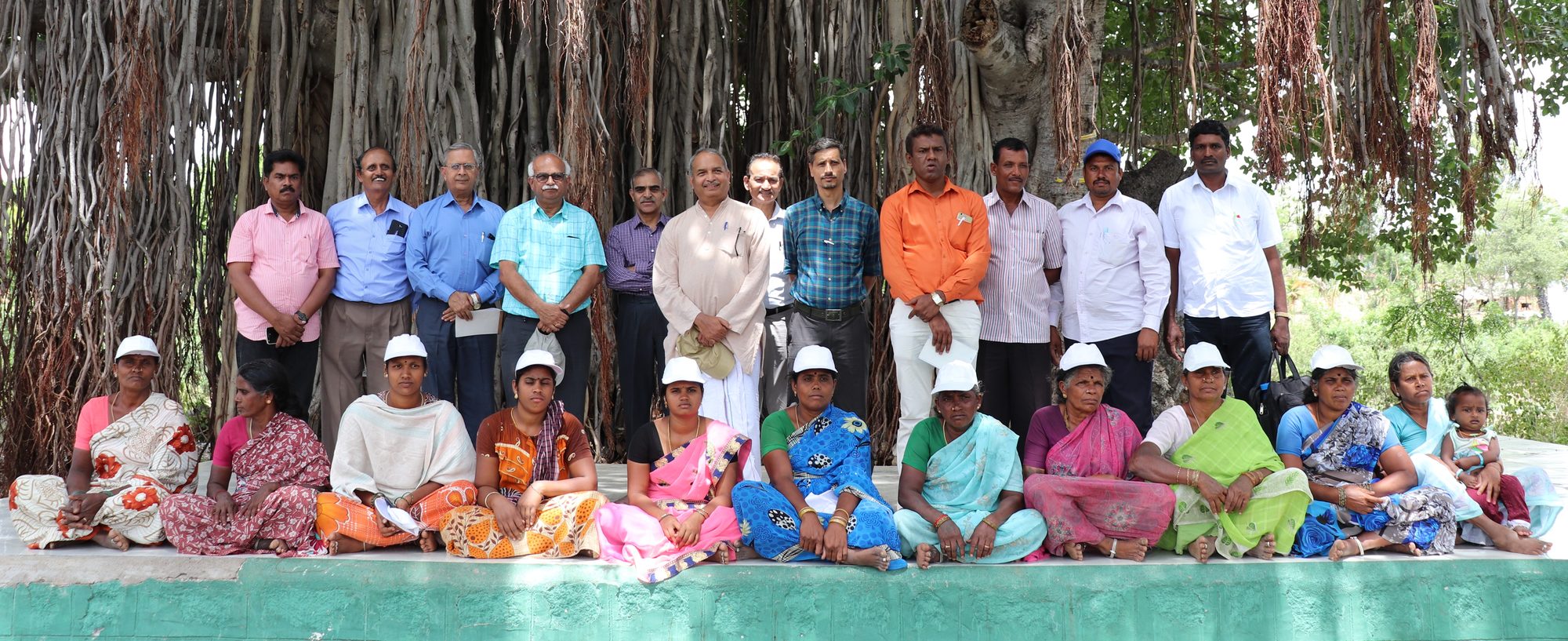 Women farmers seated in front of IDF staff and farmers under a banyan tree
